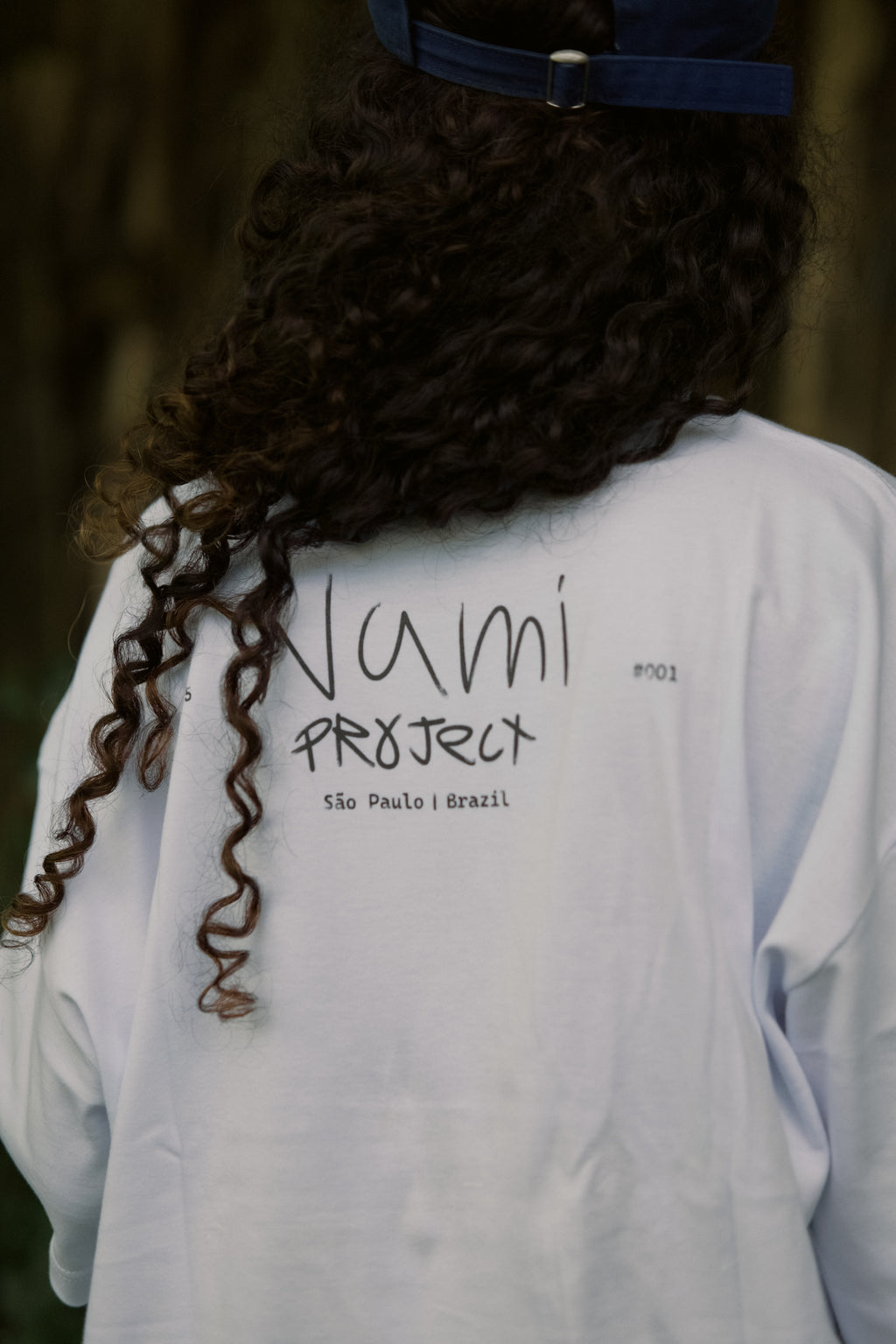Camiseta God Always First branca em uso — vista traseira