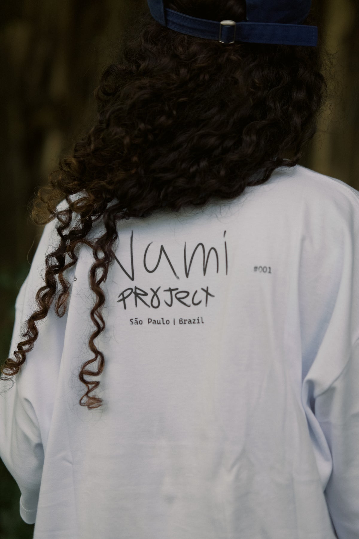 Camiseta God Always First branca em uso — vista traseira